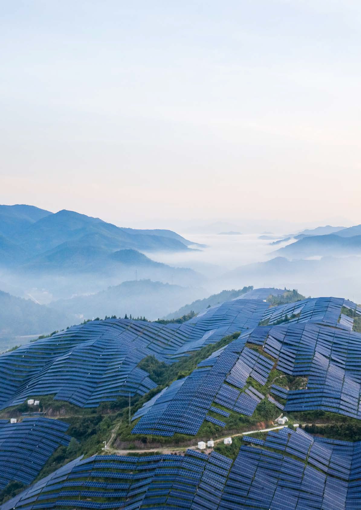 solar panels on a hill with a mountain backdrop