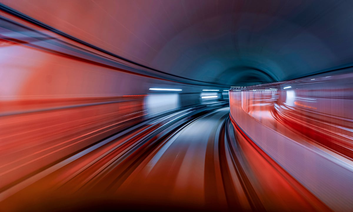 Speeding through a tunnel depicted in deep vibrant colours of red and blue