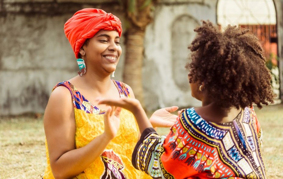 A young black woman playing with her daughter.