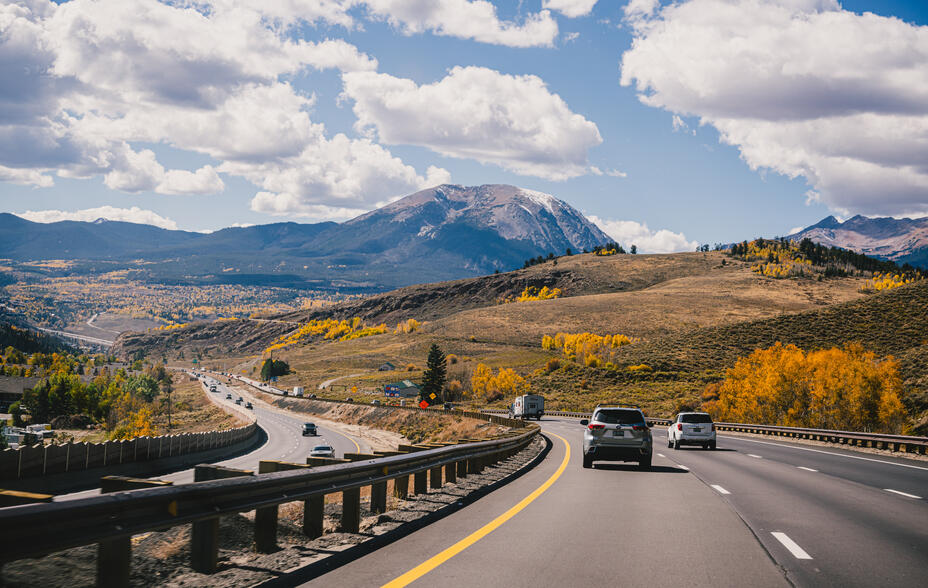 Driving down a highway in the fall through the Rocky Mountains
