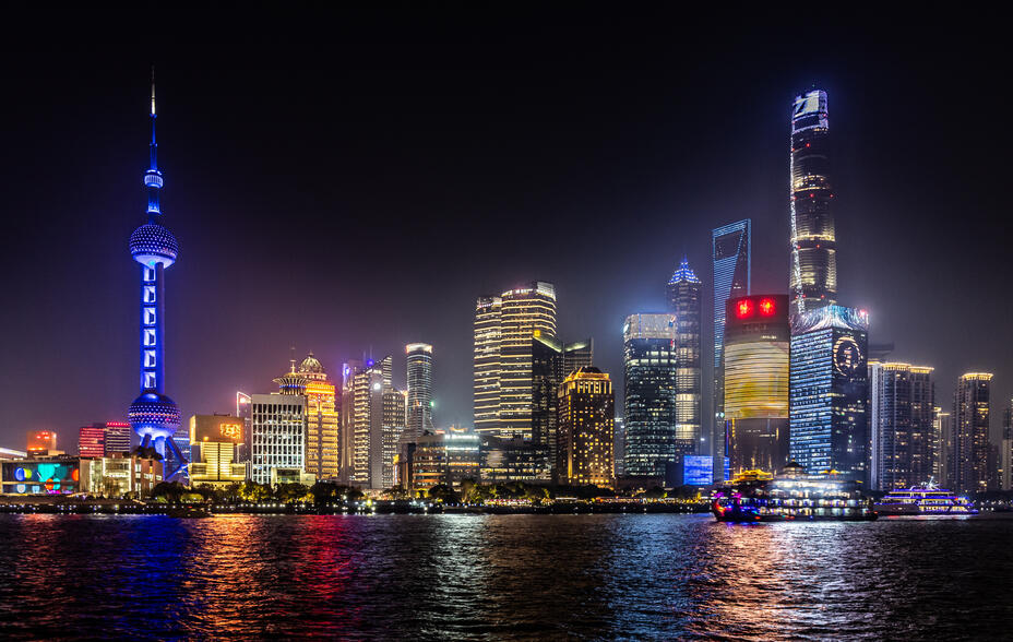 Skyline of Shanghai's Pudong business district, lit up at night.