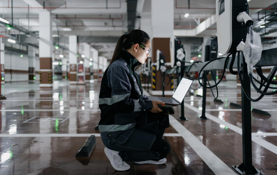 An engineer installing EV charging points in a shopping mall parking garage