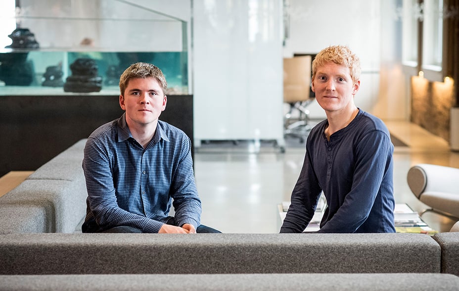 John Collison, president and co-founder of Stripe Inc., left, and Patrick Collison, chief executive officer and co-founder of Stripe Inc sit together on a grey sofa in Bloomberg Studio 1
