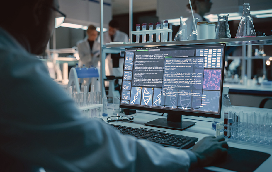 Medical research scientist coding using AI on his computer, in a biological applied science research laboratory.