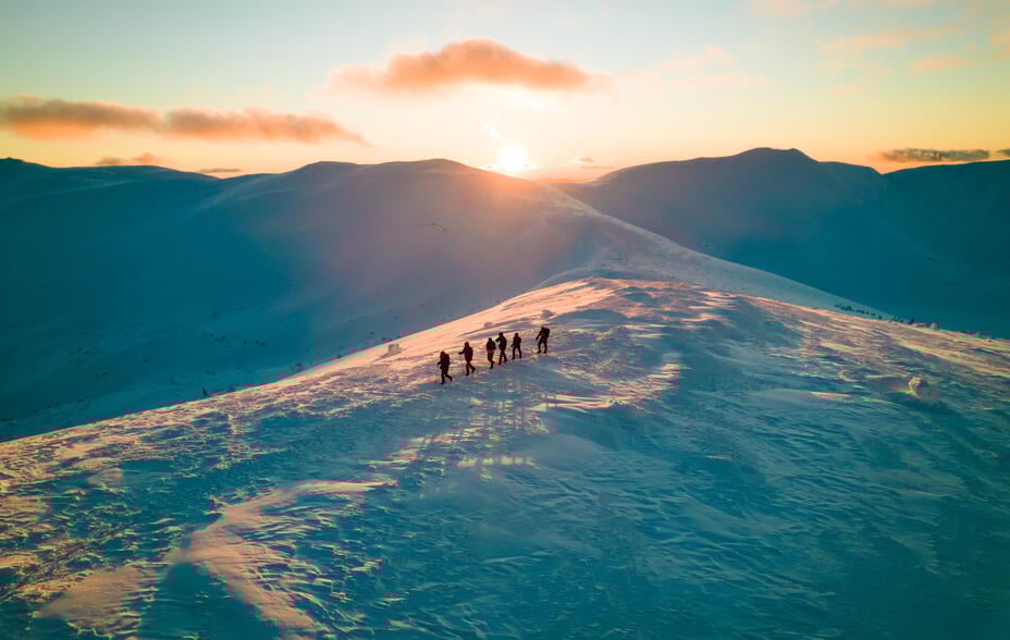 group walking on snowy mountain