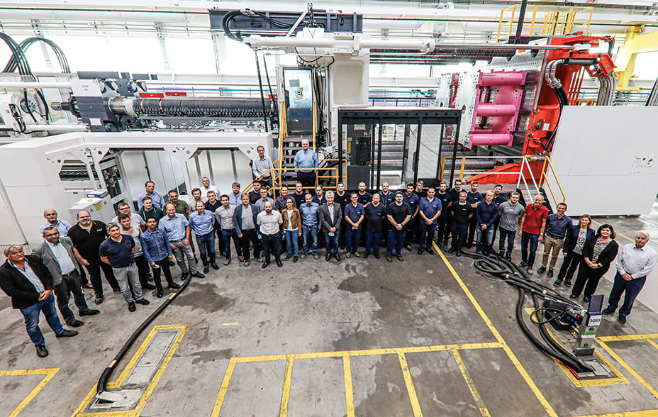 Advanced Drainage Systems' giant injection moulding machine with staff standing in front 