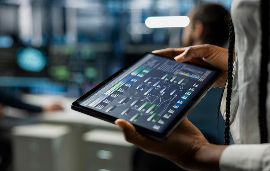 Close up of data centre developer running simulations on tablet for AI forecasting, tracking performance.